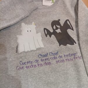 Sudadera infantil gris orgánica con estampación de becerrito fantasma y frase divertida de Halloween “¡Chas chas! Cuerno de toro, cola de lombriz, que todos los días seas muy feliz”, diseño exclusivo de ButtiBou Pamplona.