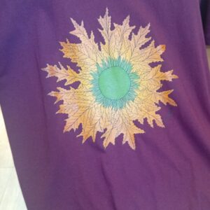 camiseta Eguzkilore color granate de ButtiBou Pamplona, símbolo navarro de protección inspirado en la flor del sol. Granate Eguzkilore t-shirt by ButtiBou Pamplona, a Navarrese protection symbol inspired by the sun flower